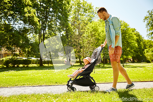 Image of happy father with child in stroller at summer park