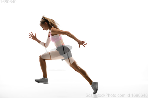 Image of Caucasian professional female runner, athlete training isolated on white studio background. Copyspace for ad.