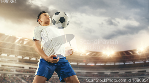 Image of Junior football or soccer player at stadium - motion, action, activity concept