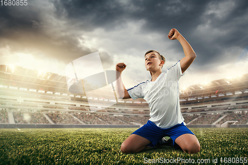 Image of Junior football or soccer player at stadium - motion, action, activity concept