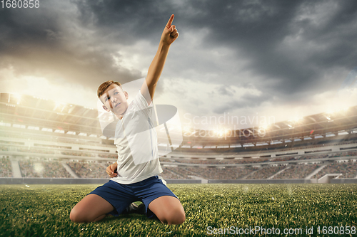 Image of Junior football or soccer player at stadium - motion, action, activity concept