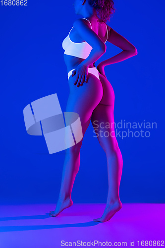 Image of Beautiful female body on blue background in neon light. Beauty, cosmetics, spa, depilation, diet and treatment, fitness concept.