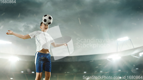 Image of Junior football or soccer player at stadium - motion, action, activity concept