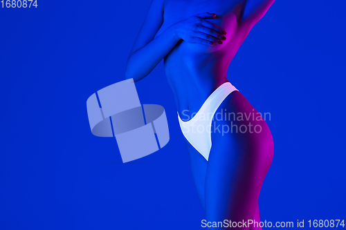 Image of Beautiful female body on blue background in neon light. Beauty, cosmetics, spa, depilation, diet and treatment, fitness concept.