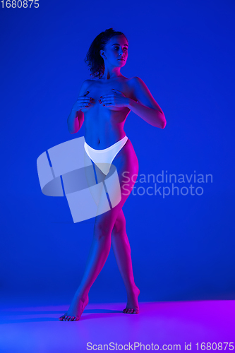 Image of Beautiful female body on blue background in neon light. Beauty, cosmetics, spa, depilation, diet and treatment, fitness concept.