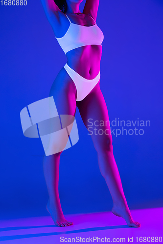 Image of Beautiful female body on blue background in neon light. Beauty, cosmetics, spa, depilation, diet and treatment, fitness concept.