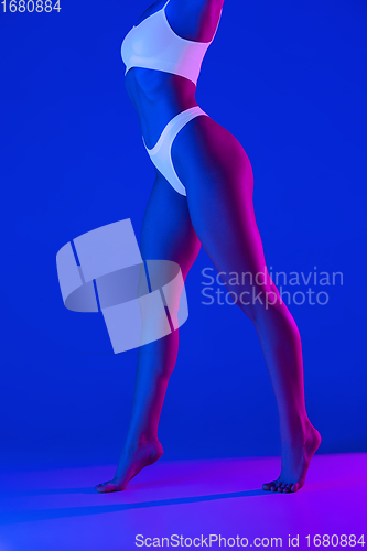 Image of Beautiful female body on blue background in neon light. Beauty, cosmetics, spa, depilation, diet and treatment, fitness concept.