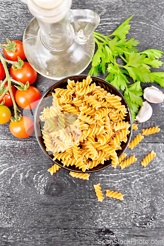 Image of Fusilli whole grain in bowl with vegetables on black board top