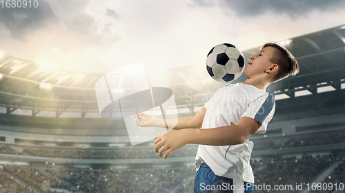 Image of Junior football or soccer player at stadium - motion, action, activity concept