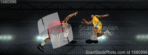 Image of Young basketball players in competitive fight, motion in flight on black background, look from the bottom. Concept of sport, movement, energy and dynamic.