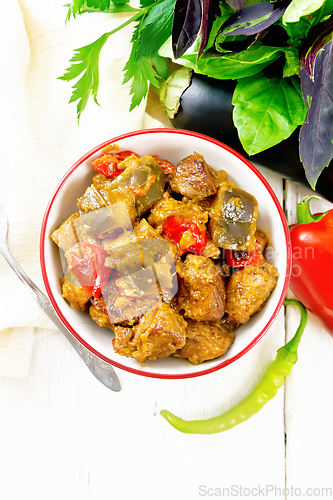 Image of Meat with eggplant and pepper in bowl on board top