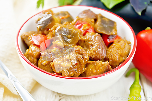 Image of Meat with eggplant and pepper in bowl on board