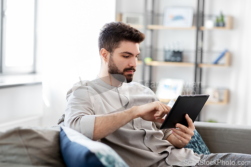 Image of man with tablet computer at home