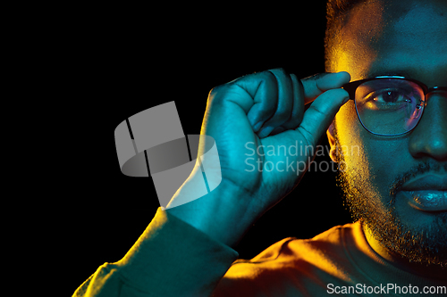 Image of young african american man in glasses over black