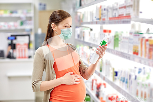Image of pregnant woman in mask choosing lotion at pharmacy
