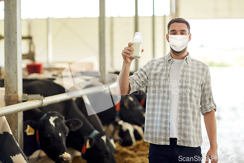 Image of man or farmer in mask with milk on dairy farm