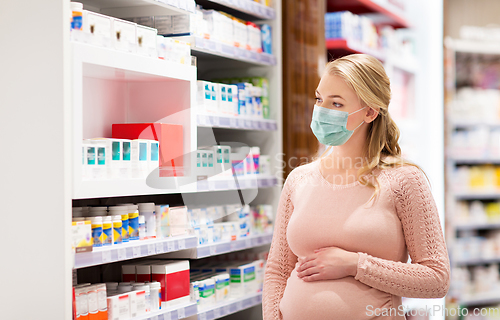 Image of pregnant woman in mask with medicines at pharmacy