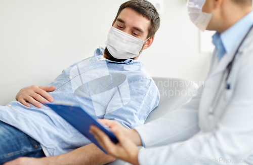 Image of male doctor and patient in masks at hospital
