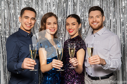 Image of happy friends toasting champagne glasses at party