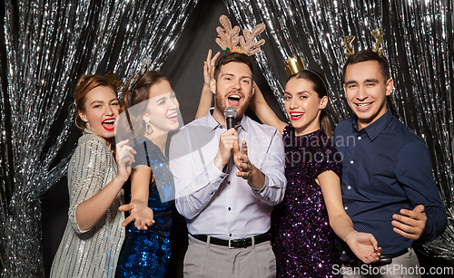 Image of friends with microphone singing at christmas party