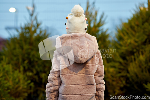 Image of little girl choosing christmas tree at market