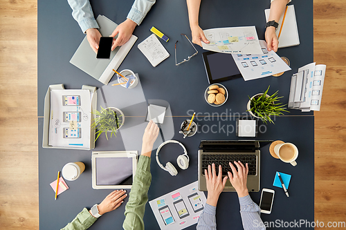 Image of business team with gadgets working at office table