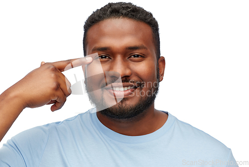 Image of african american man pointing finger to his eye