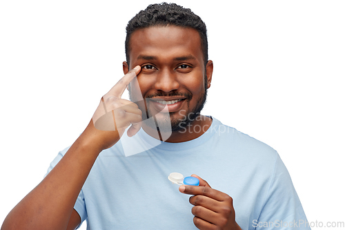 Image of young african american man applying contact lenses