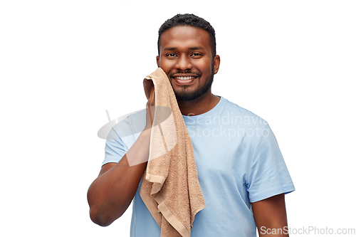 Image of african american man wiping face with bath towel