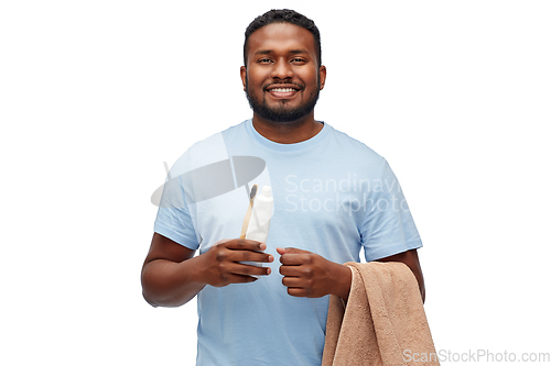 Image of smiling man with toothbrush, toothpaste and towel