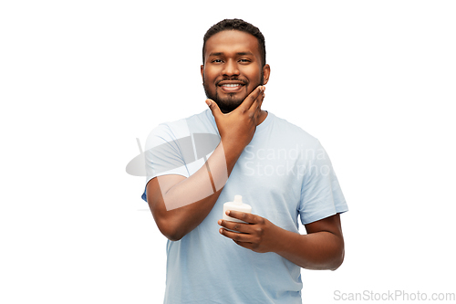 Image of happy african man applying cream to his face