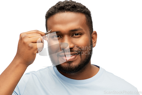 Image of african man with tweezers tweezing his eyebrow