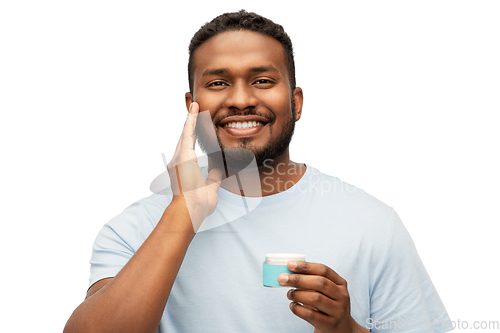 Image of happy african man applying wax to his beard