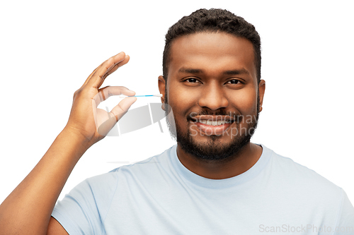 Image of african american man cleaning ear with cotton swab