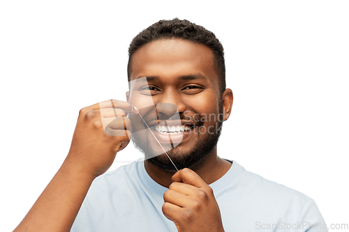 Image of happy african man with dental floss cleaning teeth