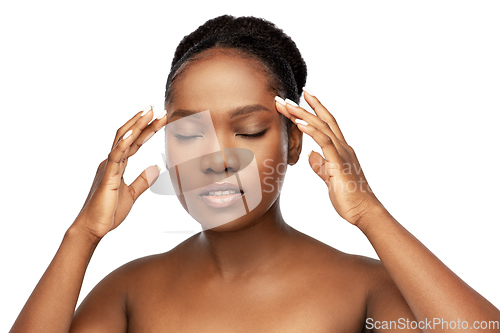 Image of portrait of african woman doing face massage