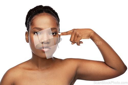 Image of beautiful african woman pointing to her eye