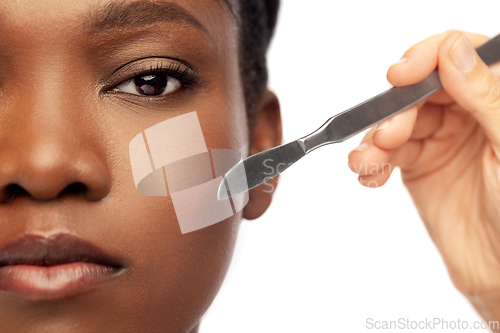 Image of face of african american woman and scalpel knife