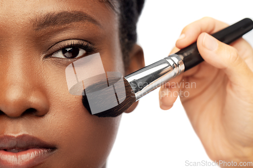 Image of face of african woman and hand with make up brush