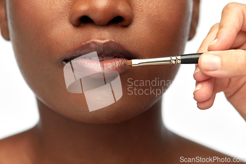 Image of face of african woman and hand with make up brush