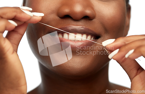 Image of african woman cleaning teeth with dental floss