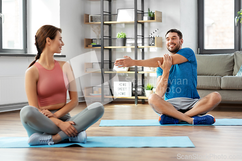 Image of happy couple exercising at home