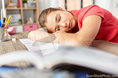 Image of tired student girl sleeping on table at home