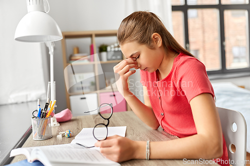 Image of tired teenage student girl with glasses at home