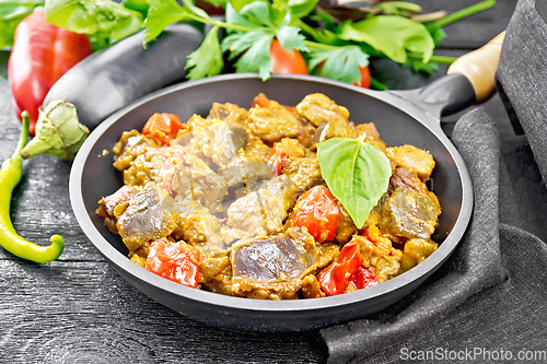 Image of Meat with eggplant and pepper in pan on board