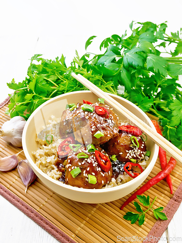 Image of Meatballs in sweet and sour sauce with rice on white board