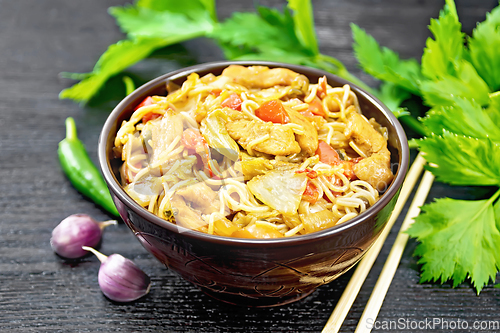 Image of Noodles with cabbage and chicken in bowl on dark board