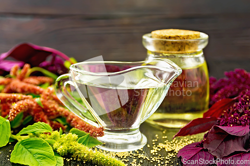 Image of Oil amaranth in gravy boat on dark board