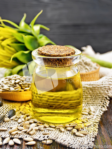 Image of Oil sunflower in jar with flour on wooden board