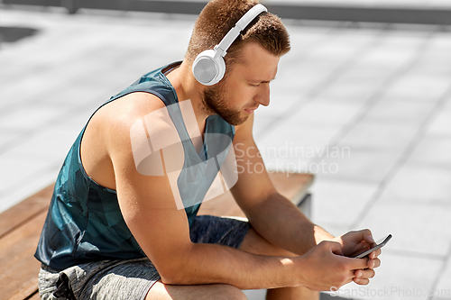 Image of young athlete man with headphones and smartphone